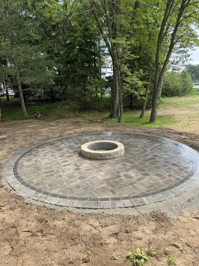 Round paver patio with a fire pit