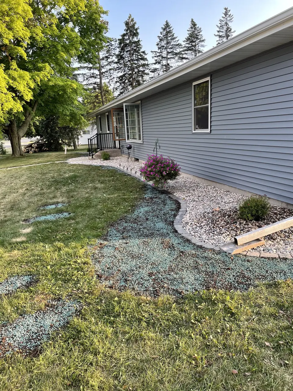 Landscaped bed with stone and plants beside a house